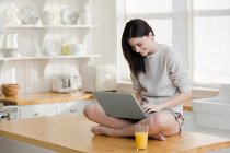 Giovane donna con computer portatile a casa — Foto stock