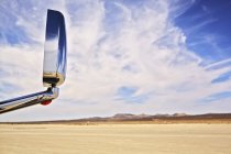 Вид на дзеркало автомобільного крила з посушливим пейзажем і хмарним блакитним небом — стокове фото