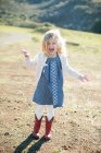 Retrato de menina no campo vestindo botas de cowboy vermelho — Fotografia de Stock