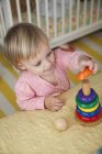 Высокий угол обзора девочки, играющей со сложенной игрушкой — стоковое фото