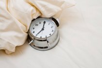 Fechar o relógio de alarme na cama — Fotografia de Stock