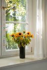 Bunch of sunflowers on windowsill — Stock Photo