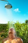 Homem desfrutando de chuveiro fresco ao ar livre — Fotografia de Stock