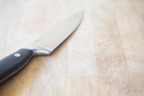 Close up of Kitchen knife on chopping board — Stock Photo