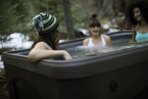 Three friends relaxing in hot tub — Stock Photo
