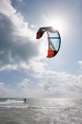 Junger Mann beim Kitesurfen im Meer — Stockfoto