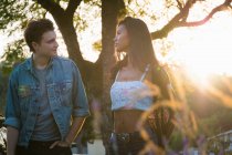 Young couple walking outdoors at sunset — Stock Photo