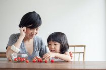 Mother and daughter counting cherries — Stock Photo