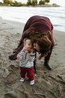 Madre sulla spiaggia baciare bambino sulla guancia, Toronto, Ontario, Canada — Foto stock
