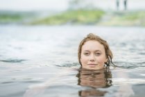 Retrato de uma jovem serena nadando na fonte termal da Lagoa Secreta (Gamla Laugin), Fludir, Islândia — Fotografia de Stock