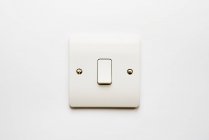 Minimalistischer Lichtschalter an weißer Wand — Stockfoto