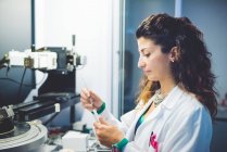 Female scientist preparing thin film sample for measurement with x-ray diffractometer — Stock Photo
