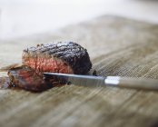 Bistecca media rara con grani di pepe, tagliata a fette con coltello — Foto stock
