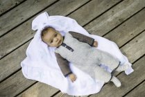 Ritratto di bambino sdraiato su coperta, vista dall'alto — Foto stock