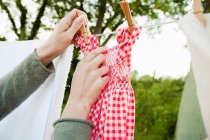 Donna appeso lavanderia su clothesline — Foto stock