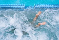 Feets out of swiming pool — Stock Photo