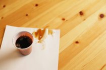Plastic cup and spilt coffee — Stock Photo