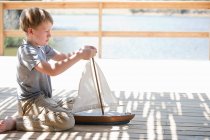 Garçon jouer avec jouet bateau — Photo de stock