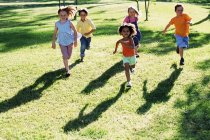 Crianças correndo em um parque — Fotografia de Stock