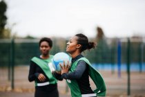 Young adult female netball player at play on netball court — Stock Photo