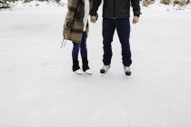 Patinaje en pareja en el lago congelado, Whitby, Ontario, Canadá - foto de stock