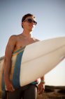Молодой человек с доской для серфинга — стоковое фото