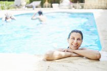 Portrait de femme mûre souriante aux cheveux mouillés dans la piscine — Photo de stock