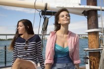 Two women on sitting on deck of sailing boat, on sea — Stock Photo