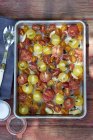 Bodegón de tomates asados, ajo, orégano y aceite de oliva - foto de stock