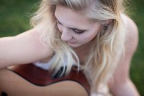 Donna che suona la chitarra in erba — Foto stock