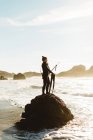 Дайвер с копьем, стоящий на скале, Биг-Сур, Калифорния, США — стоковое фото