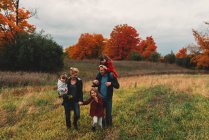 Famiglia adulta con tre figlie che passeggiano insieme nel campo rurale — Foto stock