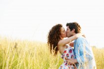 Casal beijando em um campo de trigo — Fotografia de Stock
