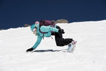 Female snowboarder falling on mountain — Stock Photo