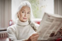 Senior femme lecture journal — Photo de stock
