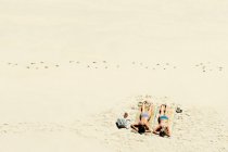 Two girls sunbathing on sandy beach — Stock Photo