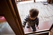 Молодий хлопчик у дверному отворі шале — стокове фото