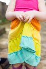 Молода дівчина тримає барвисту спідницю, середня секція, крупним планом — стокове фото