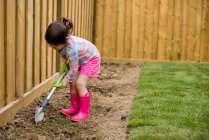 Молодая девушка копает в саду — стоковое фото