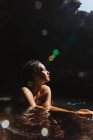 Donna in grotta piena d'acqua e guardando altrove, Oahu, Hawaii, Stati Uniti d'America — Foto stock