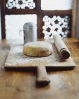Dough and rolling pin on wooden chopping board — Stock Photo