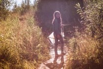 Девочка-подросток держит воздушного змея, оглядываясь с грязи — стоковое фото