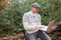 Чоловік на відкритому повітрі з ноутбуком і велосипедом — стокове фото