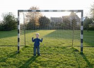 Garçon acclamant dans le but sur le terrain de football — Photo de stock