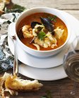 Bowl of bouillabaisse with crusty bread — Stock Photo