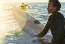 Junge Surferin watet im Meer, Newport Beach, Kalifornien, Vereinigte Staaten — Stockfoto