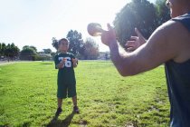 Boy and grandfather playing catch with football — Stock Photo