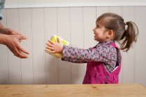 Little girl giving a gift to adult — Stock Photo