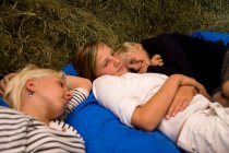 Meninas e menino dormindo no celeiro de feno — Fotografia de Stock