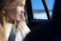 Jeune fille regardant par la fenêtre de la voiture — Photo de stock